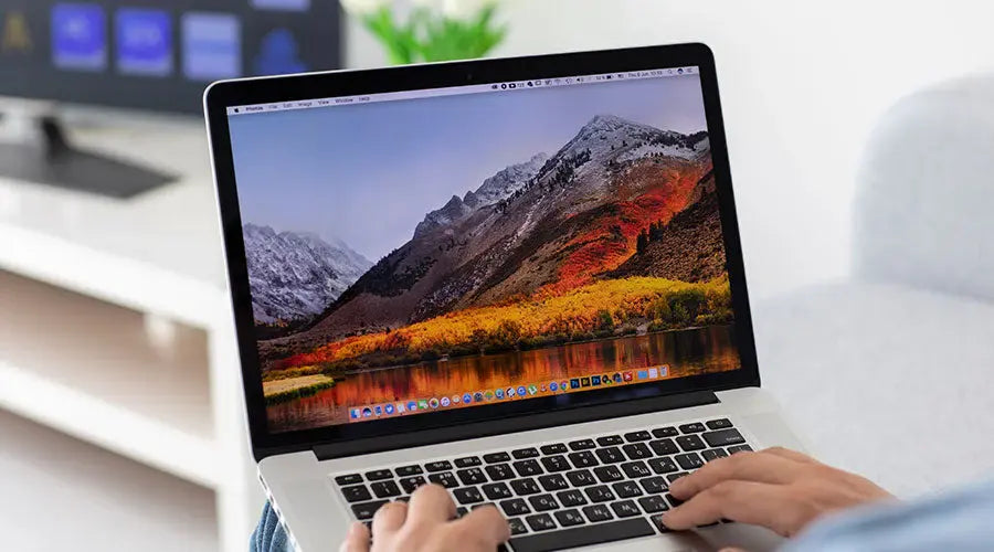 Customer examining MacBook Pro condition before buying at PayMore Milford